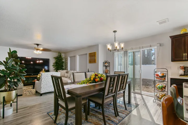 Open-concept living space featuring wood-finish flooring and a contemporary chandelier