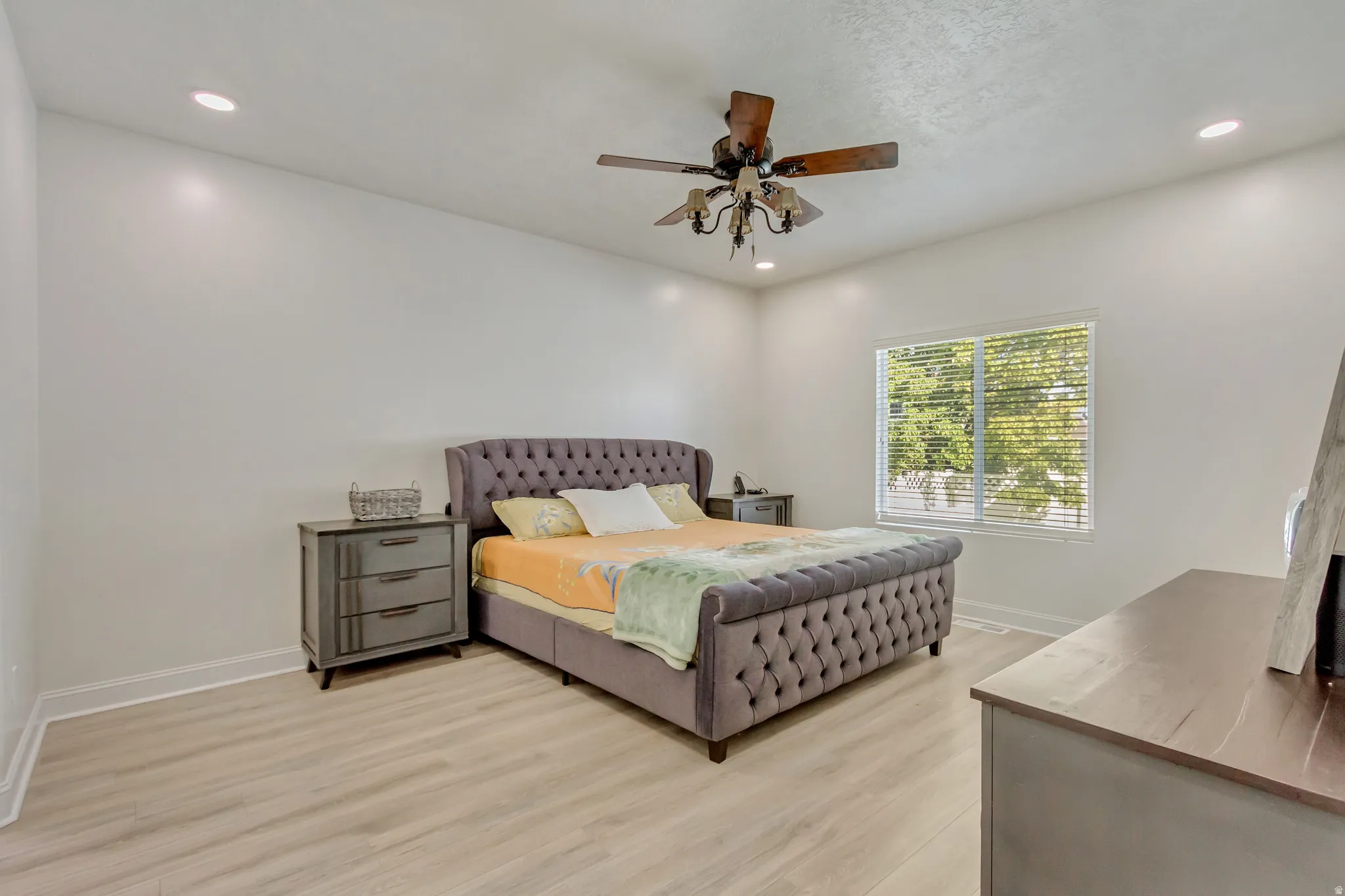 Bright room featuring light wood-finish flooring and recessed lighting