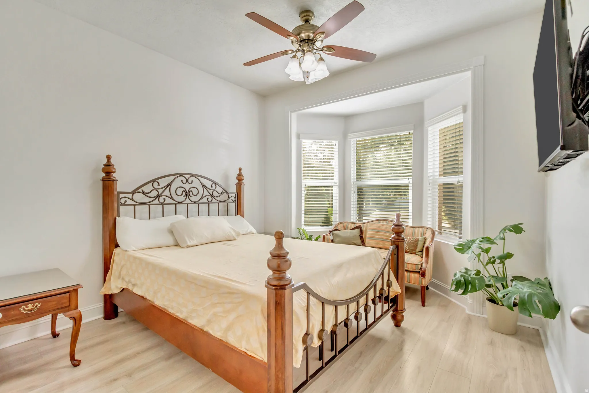 Bright room featuring wood-finish flooring and a ceiling fan