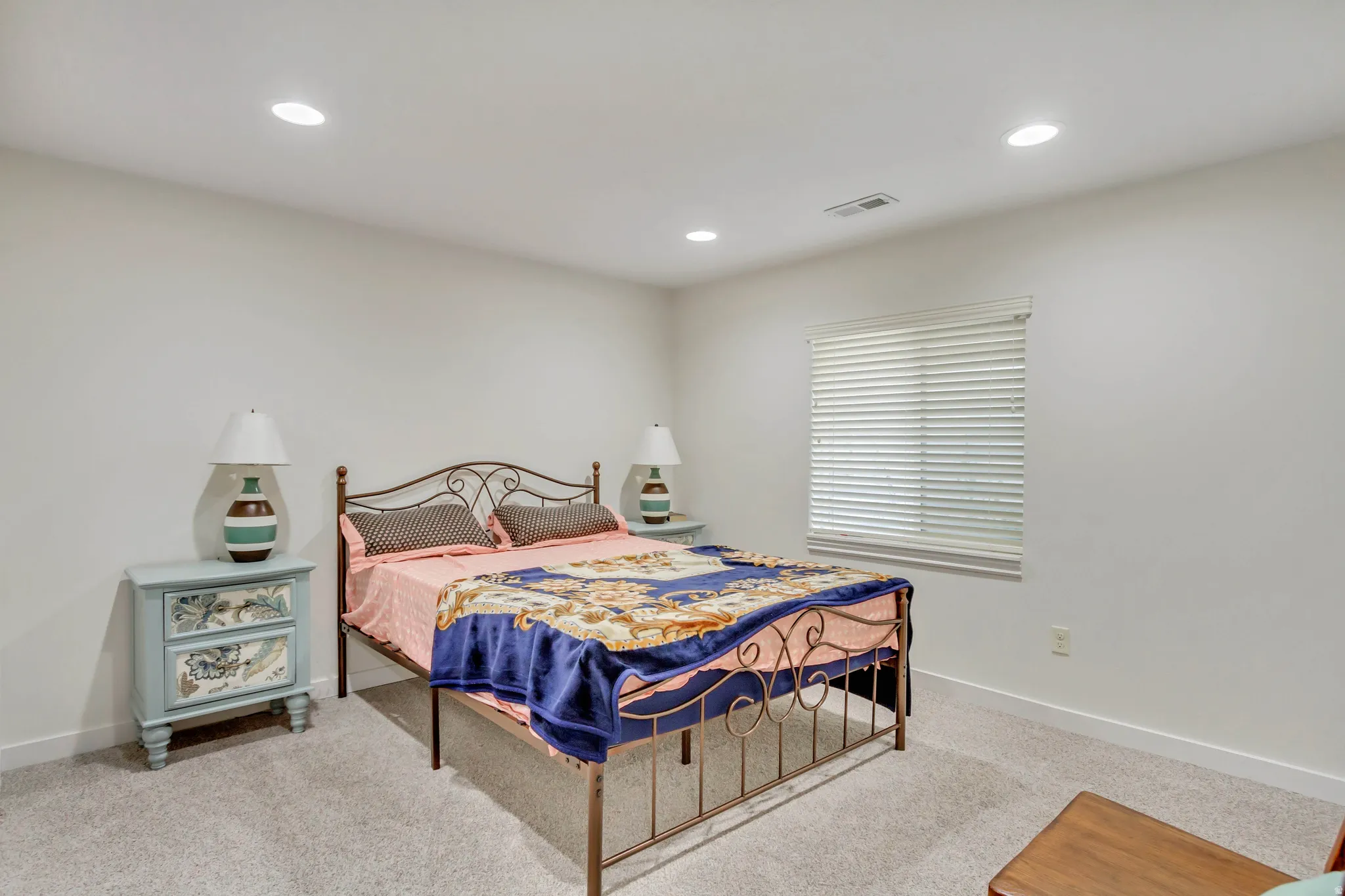 Recessed lighting illuminating a spacious room with light-colored carpeting