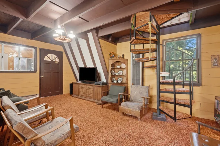 Open living space featuring a spiral staircase with carpeted treads