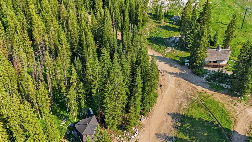 Mountain setting featuring a tree-lined landscape and two distinct structures