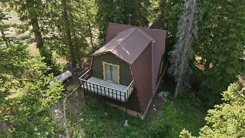 Cabin-style residence featuring a metal roof and an elevated wood deck