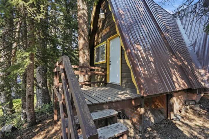 A-frame structure featuring wood siding and a corrugated metal roof