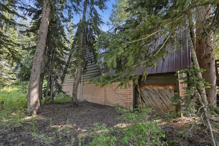 Wood-sided structure with a metal roof and a prominent wooden barn door