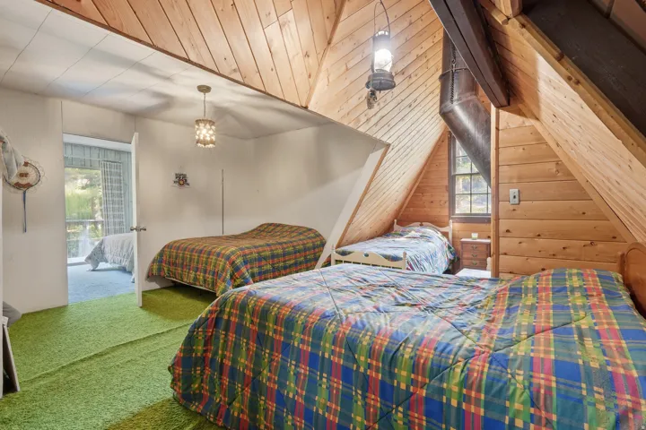 Vaulted wood-paneled ceilings with exposed beams, a built-in window, and a unique suspended light fixture