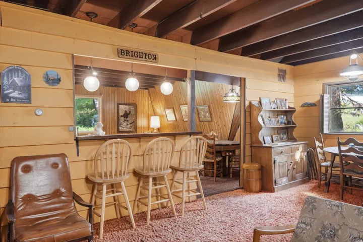 Wood-paneled room featuring a built-in bar with three pendant lights