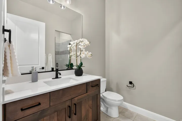 Bathroom vanity with a white countertop and integrated sink, complemented by a matte black faucet