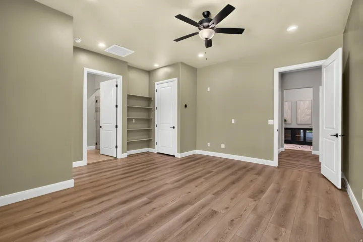 Spacious room featuring wood-finish flooring, recessed lighting, and a ceiling fan