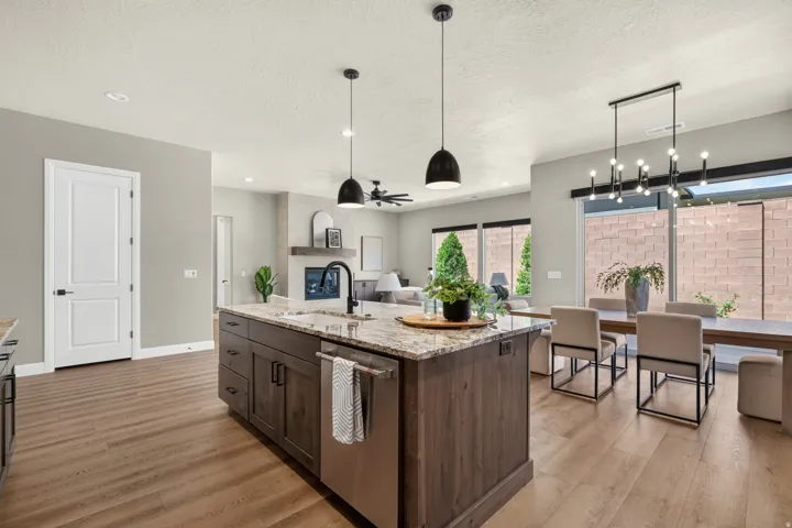 Spacious kitchen island with an integrated sink and dishwasher, featuring granite countertops and wood-finish cabinetry