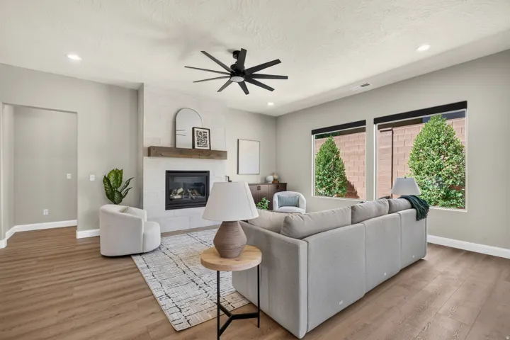 Living area featuring wood-finish flooring, a contemporary ceiling fan, and recessed lighting
