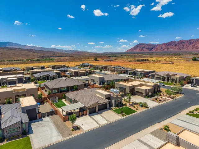 Modern desert community featuring single-story residences with stucco and stone exteriors, integrated garages, and low-maintenance landscaping