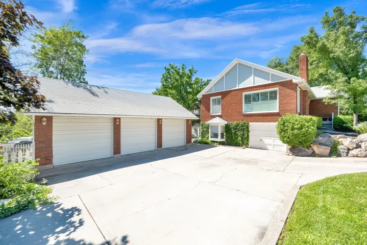 Brick exterior with multiple windows, a three-car garage, and an additional single-car garage