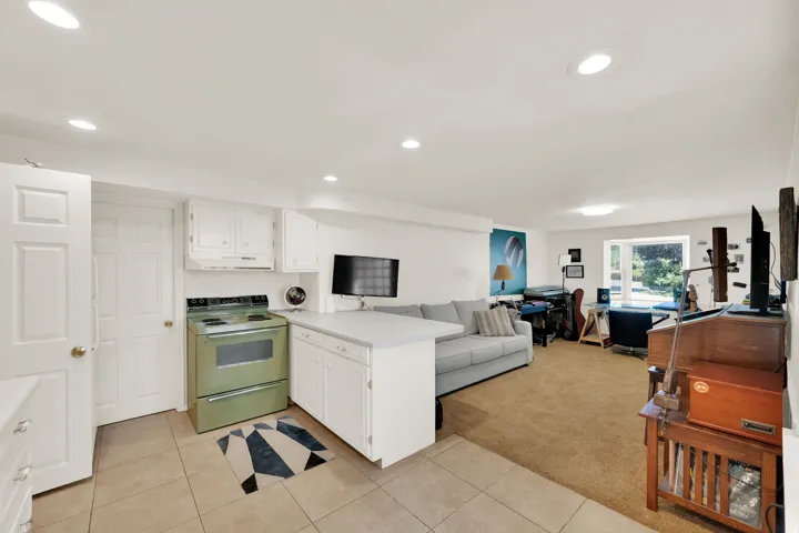 Integrated living space featuring a full kitchen with white cabinetry and a vintage-style range