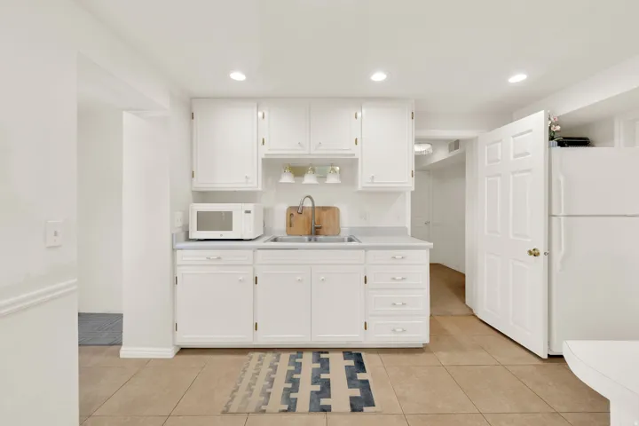Compact kitchen with white cabinetry and light-colored countertops
