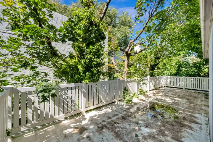 Outdoor patio space featuring a white picket fence perimeter