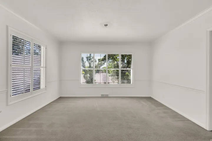 Bright interior room featuring neutral wall tones and light-colored carpet flooring