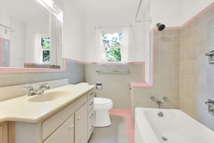 Bathroom featuring a single vanity with an integrated sink, polished chrome faucet, and under-sink storage