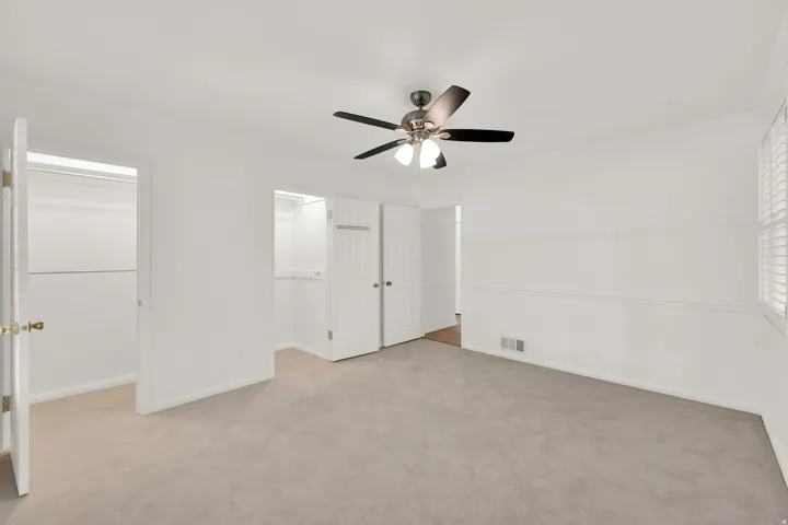 Light-colored carpeting complementing white walls with chair rail molding
