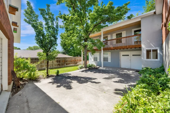 Property exterior featuring a gray stucco finish and a wood-railed balcony
