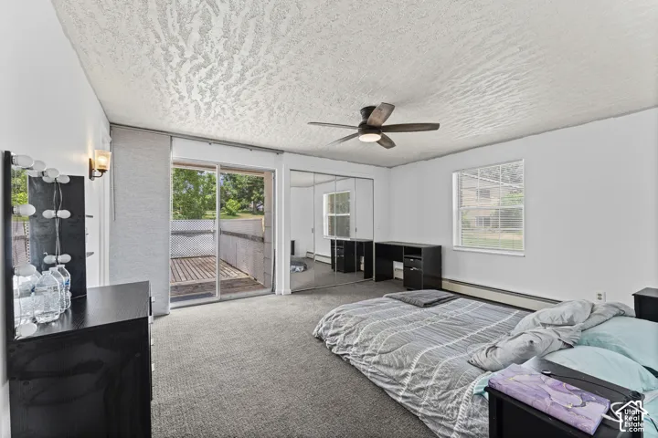 Room featuring a sliding glass door to an outdoor deck, a single window, ceiling fan with integrated lighting, and mirrored closet doors