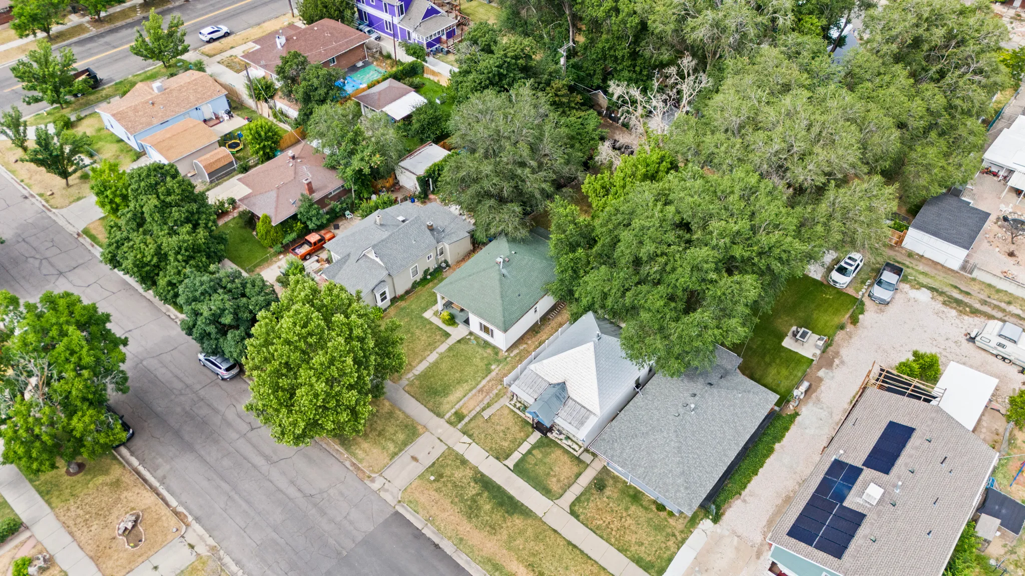 Residential neighborhood featuring mature trees, paved streets, and a variety of architectural styles