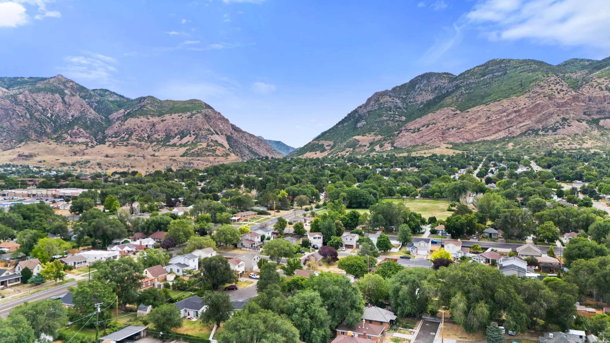 Expansive neighborhood framed by mountainous terrain and abundant mature trees