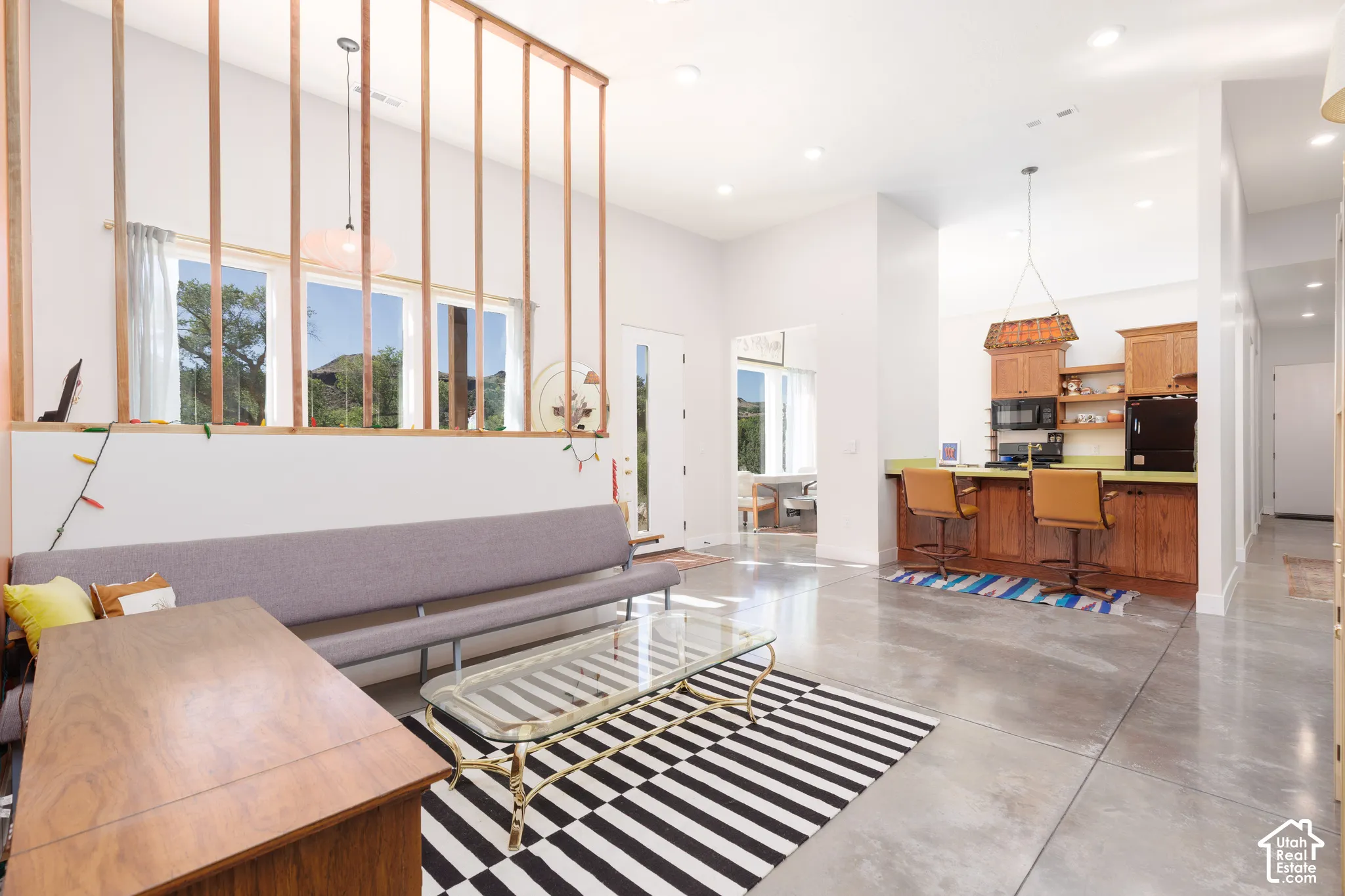 Open-concept living space featuring high ceilings and polished concrete flooring