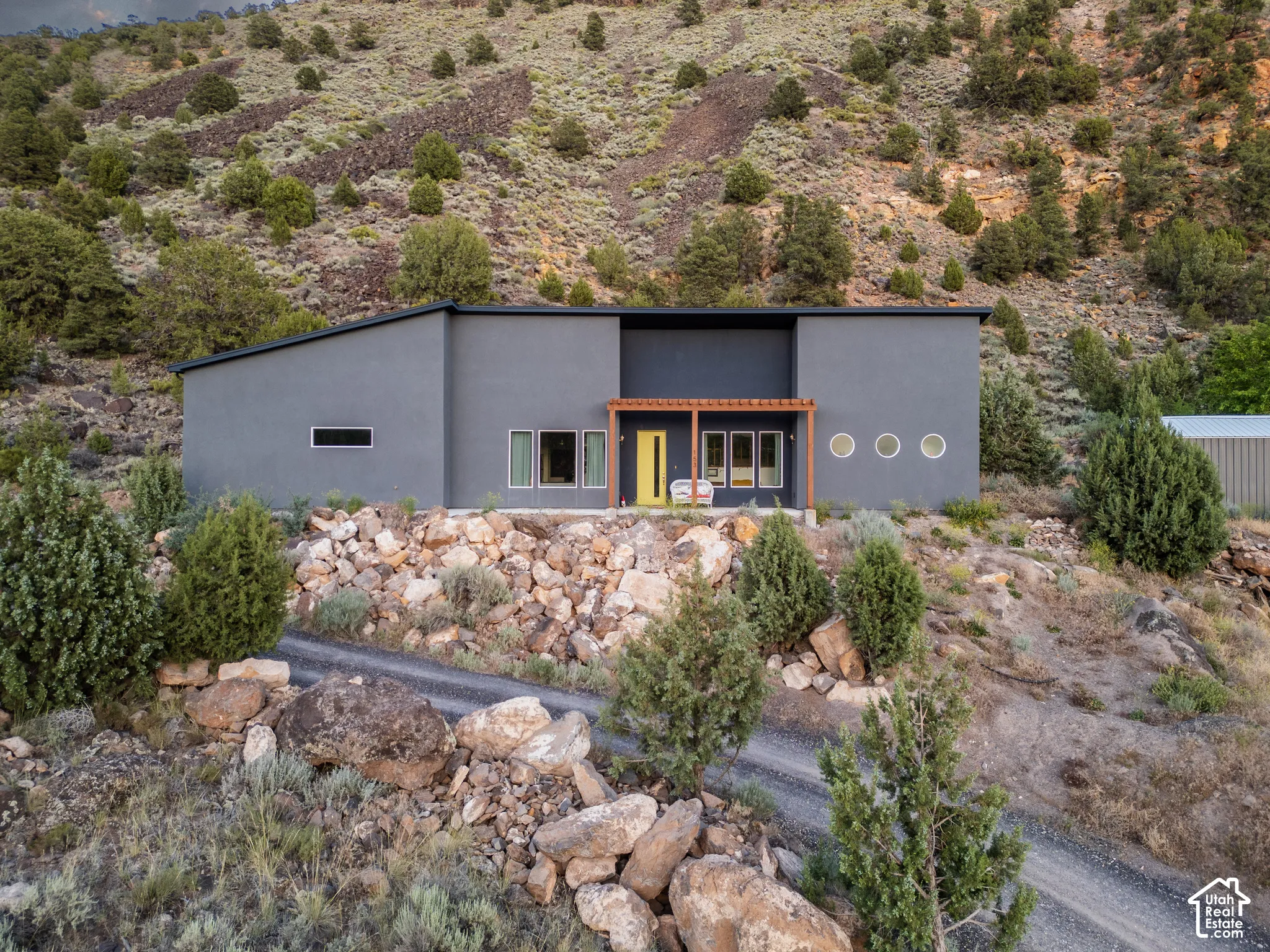 Contemporary residence featuring a flat roofline and grey stucco exterior