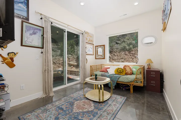 Sliding glass door opening to outdoor space, complemented by a large horizontal window