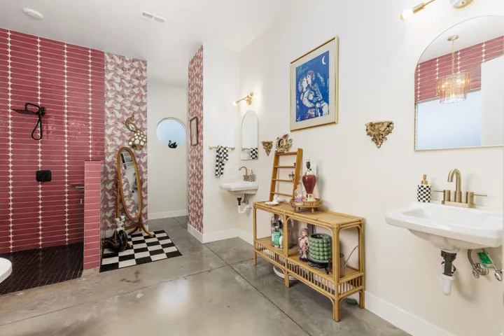Spacious bathroom featuring concrete flooring and a walk-in shower with crimson tile
