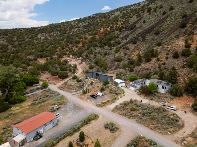 Multiple structures situated on a sloped, natural landscape with mature vegetation