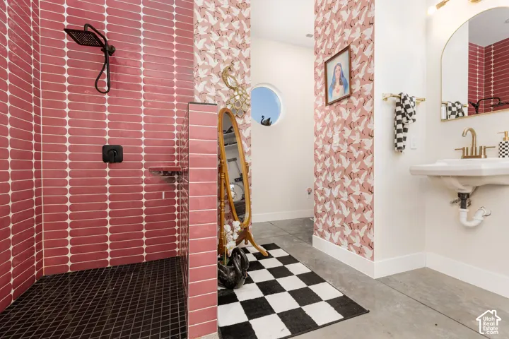 Walk-in shower with vertical pink tiled walls and dark square floor tiles