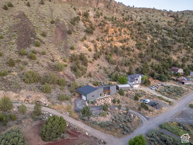 Contemporary gray exterior featuring a dark roof, attached garage, and a gravel driveway