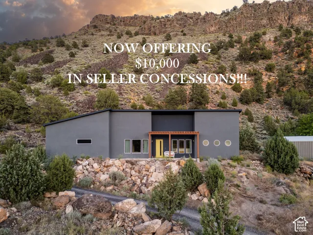 Modern exterior featuring dark smooth stucco finish, shed roofline, natural wood pergola, circular port windows, and contrasting bright entryway door