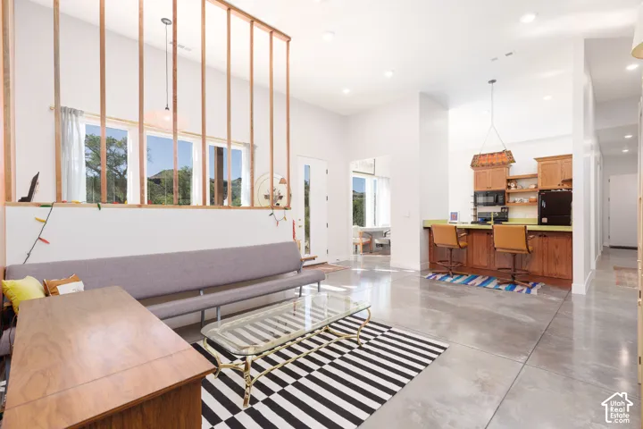 Open-concept living space featuring high ceilings and polished concrete flooring