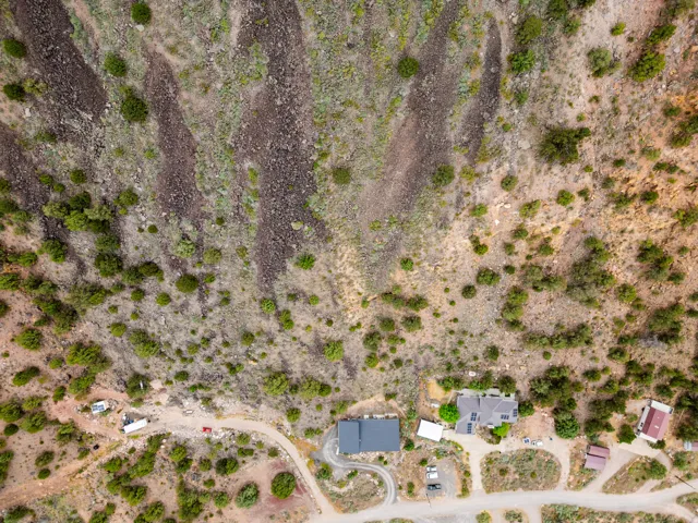 Elevated mountain terrain featuring a single-family residence with a dark-pitched roof and solar panels