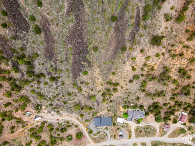 Elevated mountain terrain featuring a single-family residence with a dark-pitched roof and solar panels