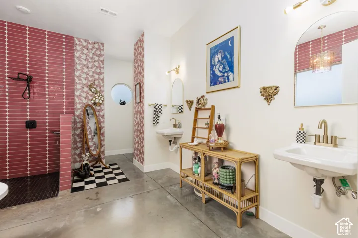 Spacious bathroom featuring concrete flooring and a walk-in shower with crimson tile