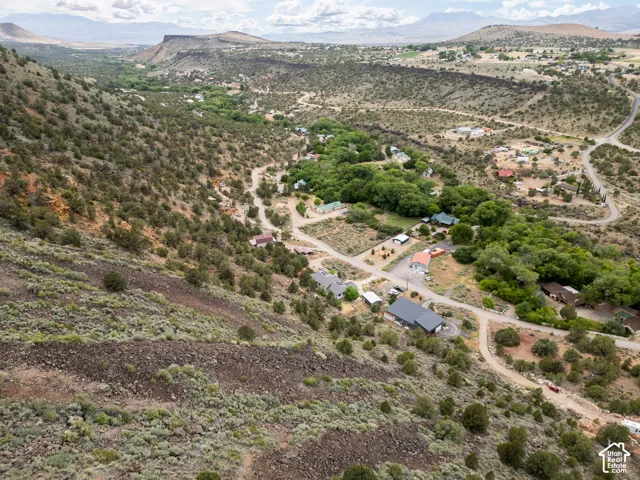 Mountainous terrain featuring diverse vegetation, residential structures, and winding roads