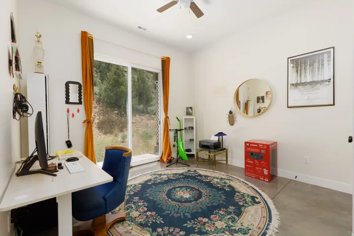 Room featuring white walls and a large sliding glass door, providing ample natural light
