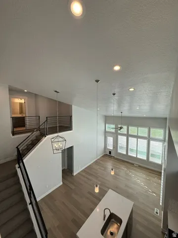 High vaulted ceiling with recessed lighting and pendant fixtures