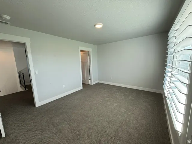Neutral wall paint, plush carpet flooring, white trim, recessed lighting, and plantation shutters