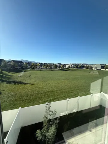 Expansive green space bordered by a white privacy fence
