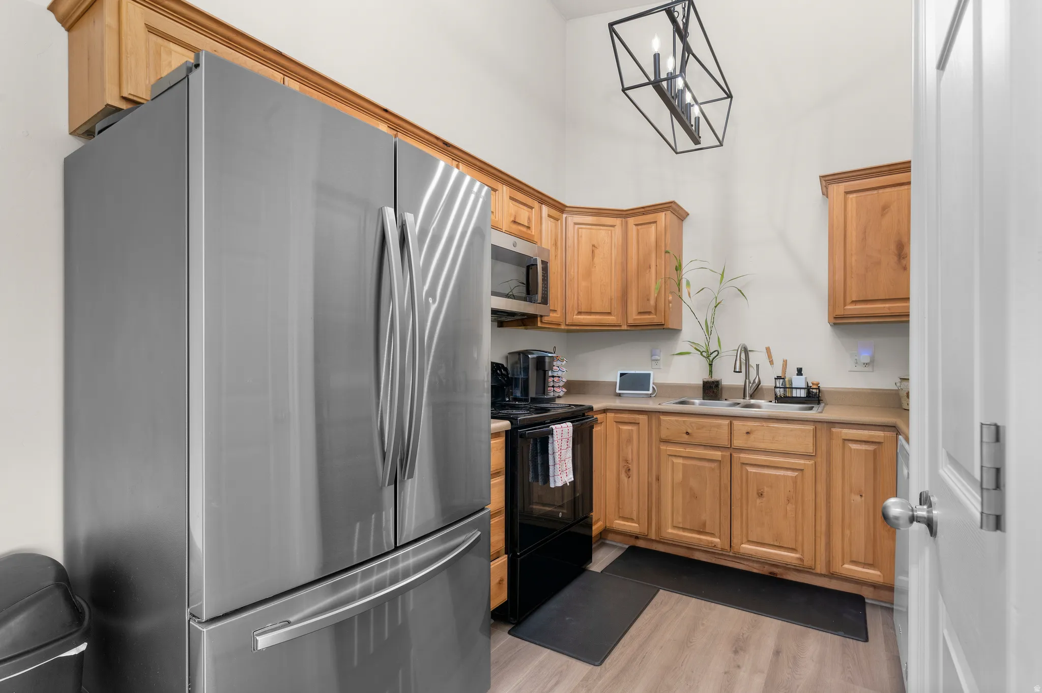Compact kitchen featuring stainless steel appliances, light wood-finish cabinetry, and neutral countertops