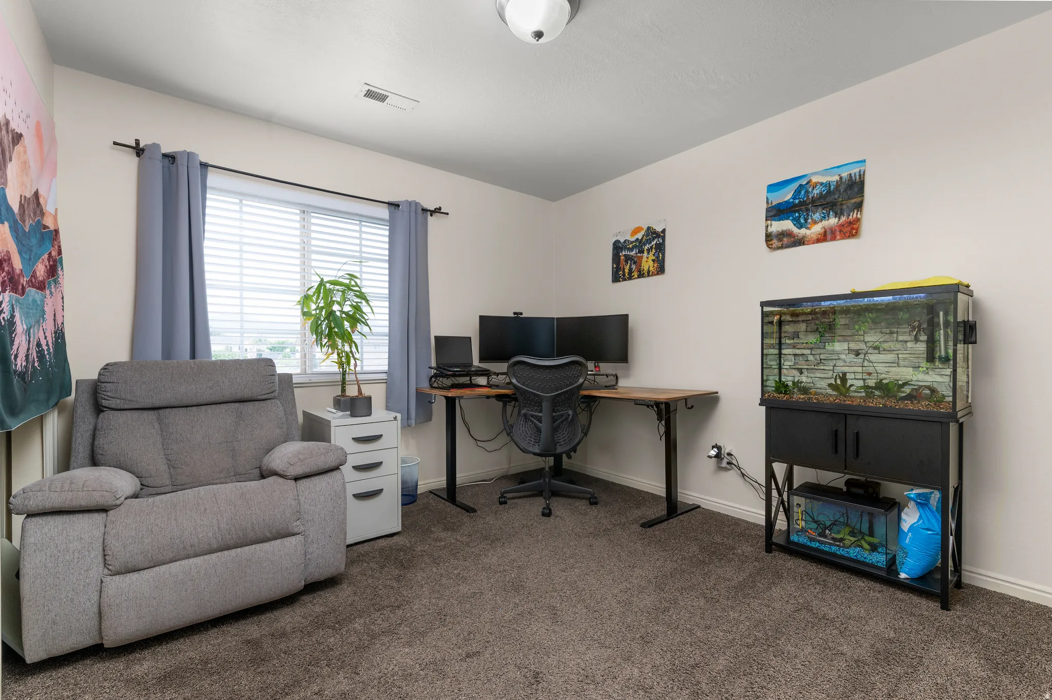 Carpeted room featuring a window with horizontal blinds, providing natural light