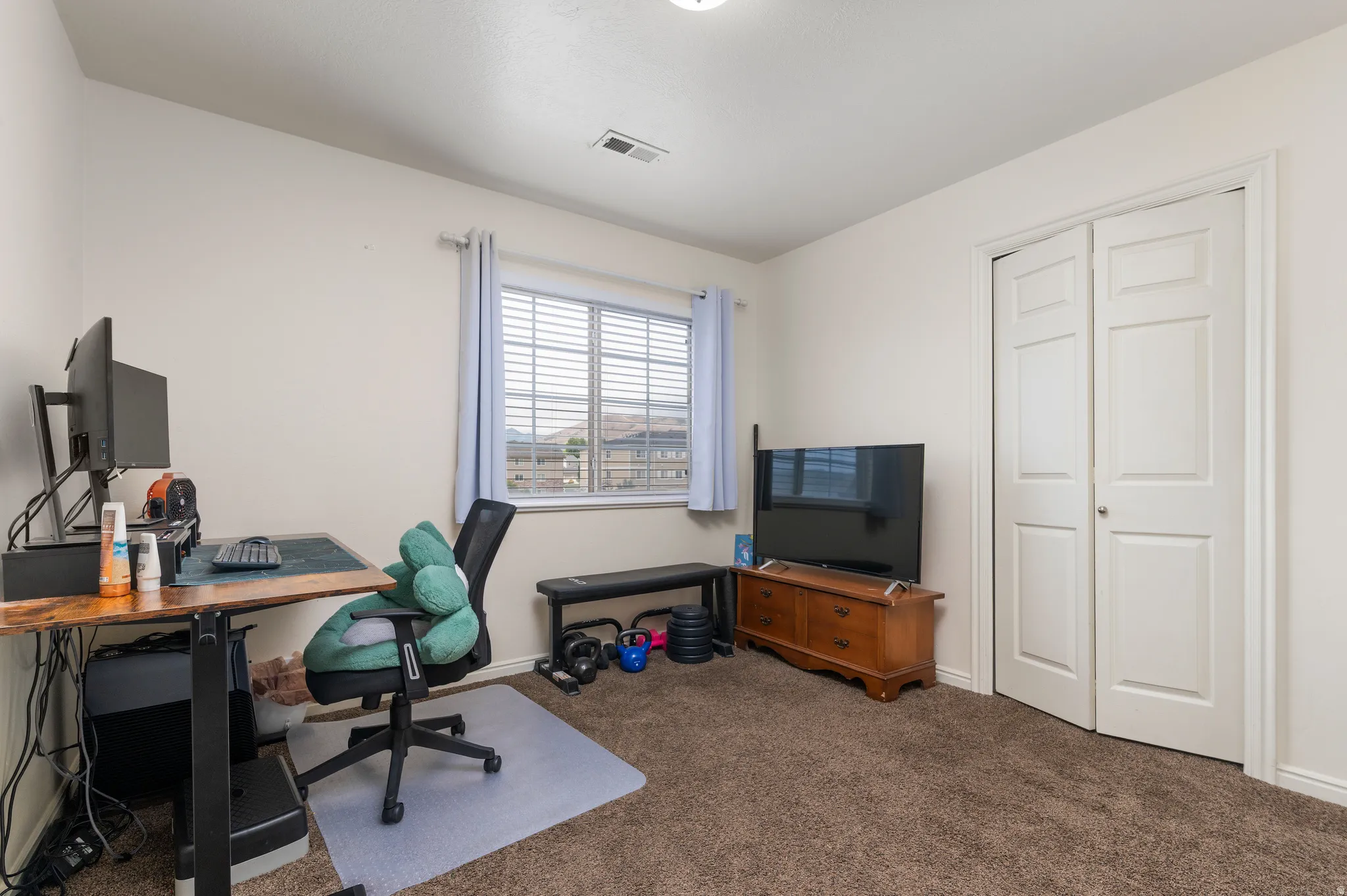 Carpeted room featuring a window with horizontal blinds, bi-fold closet doors, and recessed lighting