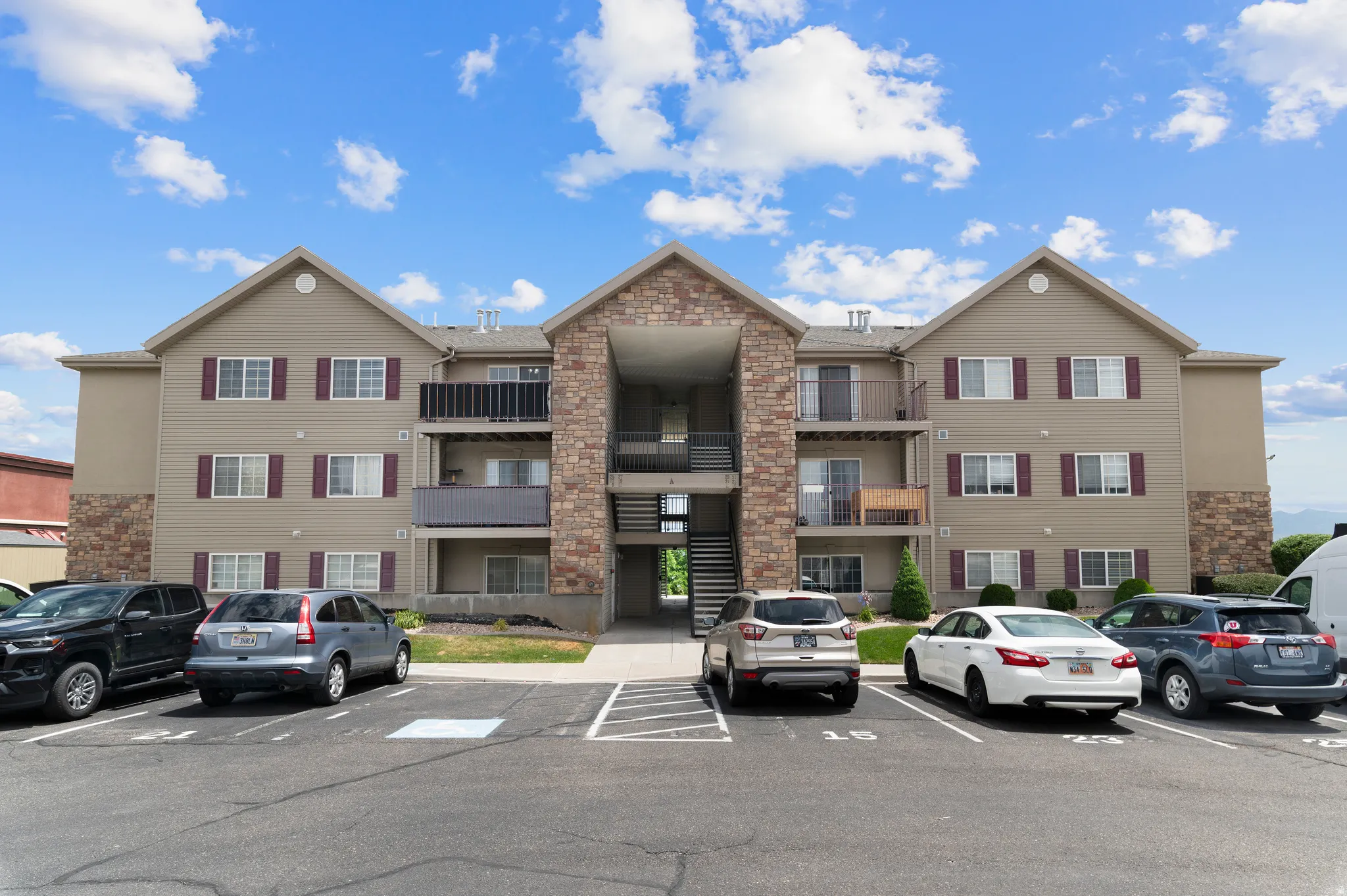 Multi-story building featuring tan siding and stone accents