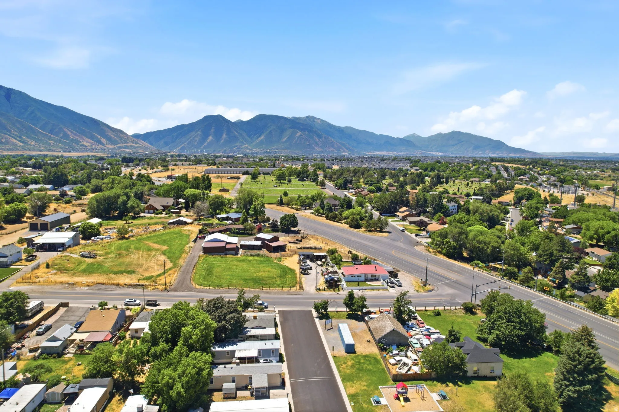 Expansive aerial perspective showcasing a rural-suburban landscape framed by distant mountains