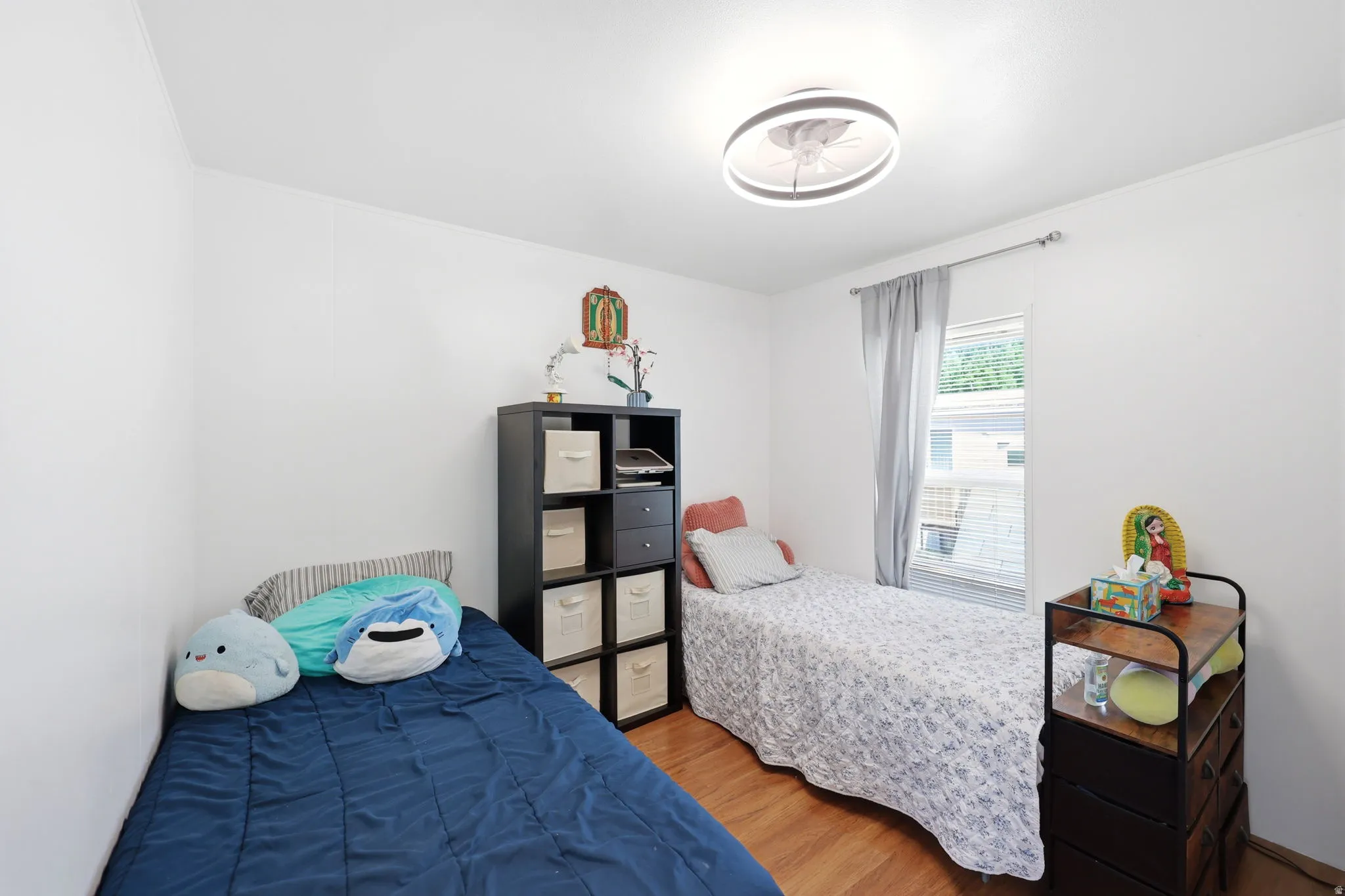 Bright room featuring light wood-finish flooring, white walls, and a contemporary ceiling light fixture